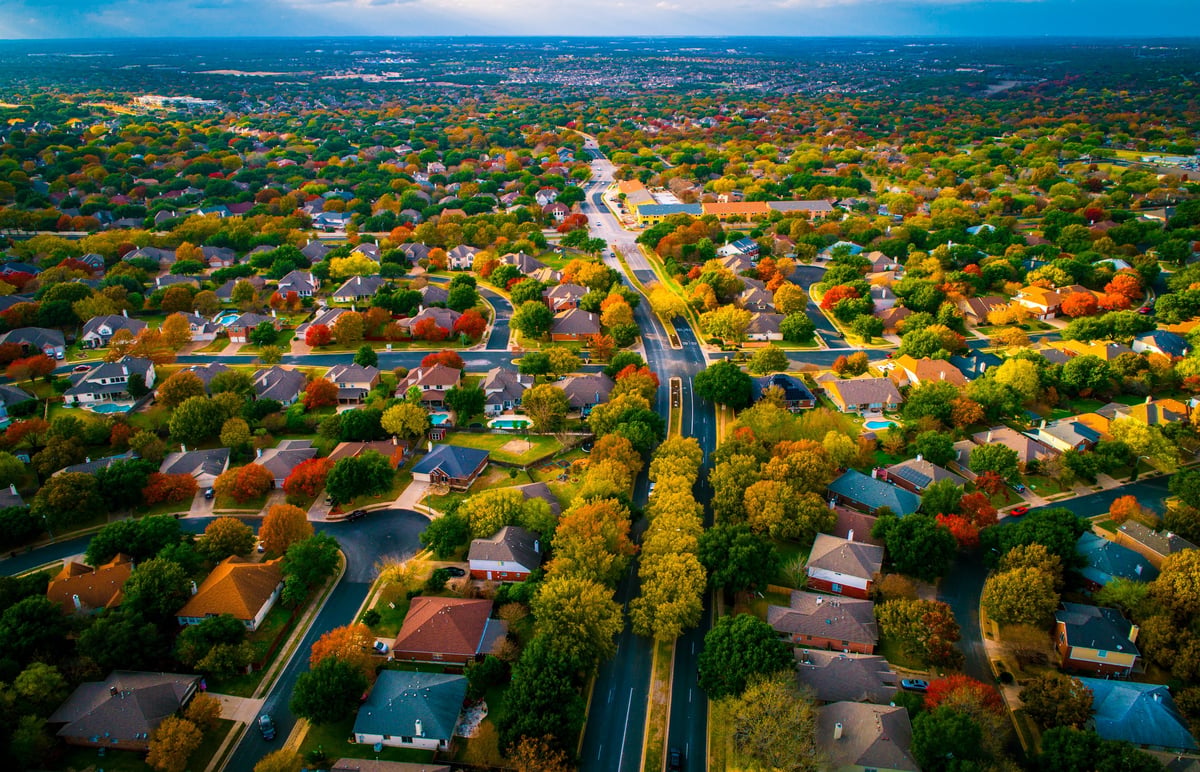 Aerial autumn view high above a suburban neighborhood of houses and rooftops
