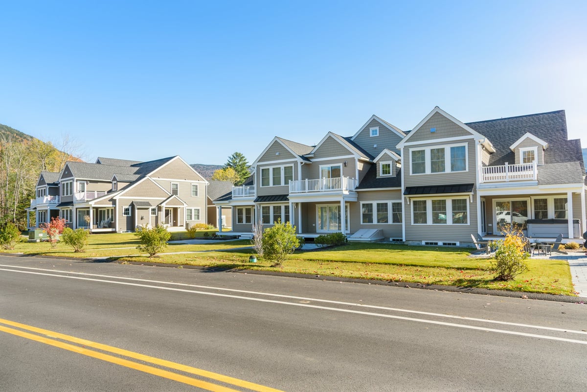 Modern row houses along a road in a new housing development on a clear autumn day